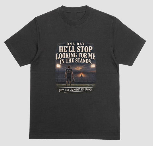 A black short-sleeve t-shirt with a graphic print on the front. The graphic features a football player on a field at sunset with the text 'ONE DAY HE'LL STOP LOOKING FOR ME IN THE STANDS.