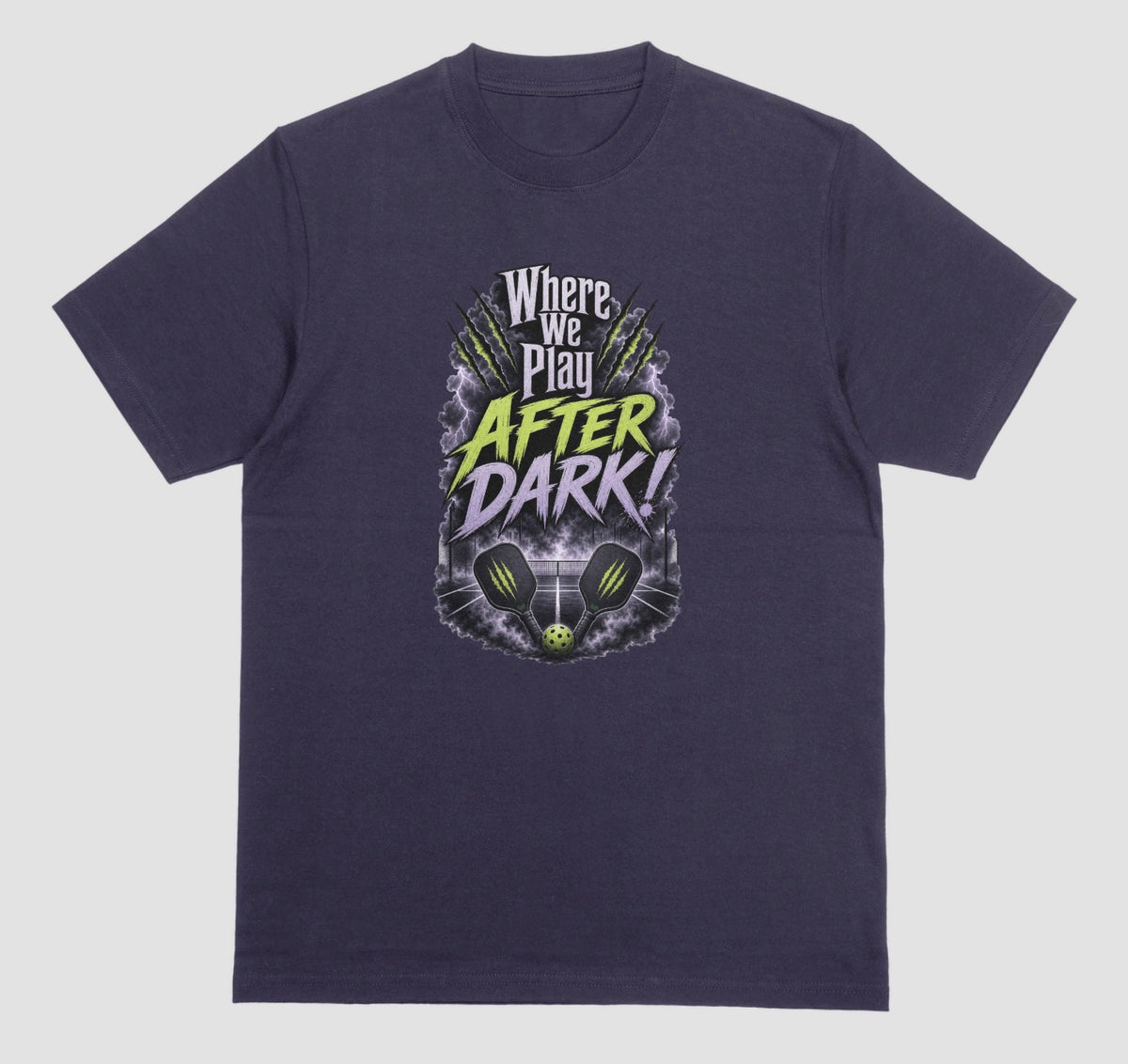A Blackberry purple t-shirt with a spooky pickleball graphic reading 'Where We Play After Dark!' showing two crossed paddles and a ball on a court inside a lightning-filled storm cloud.
