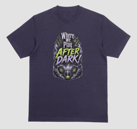 A Blackberry purple t-shirt with a spooky pickleball graphic reading 'Where We Play After Dark!' showing two crossed paddles and a ball on a court inside a lightning-filled storm cloud.