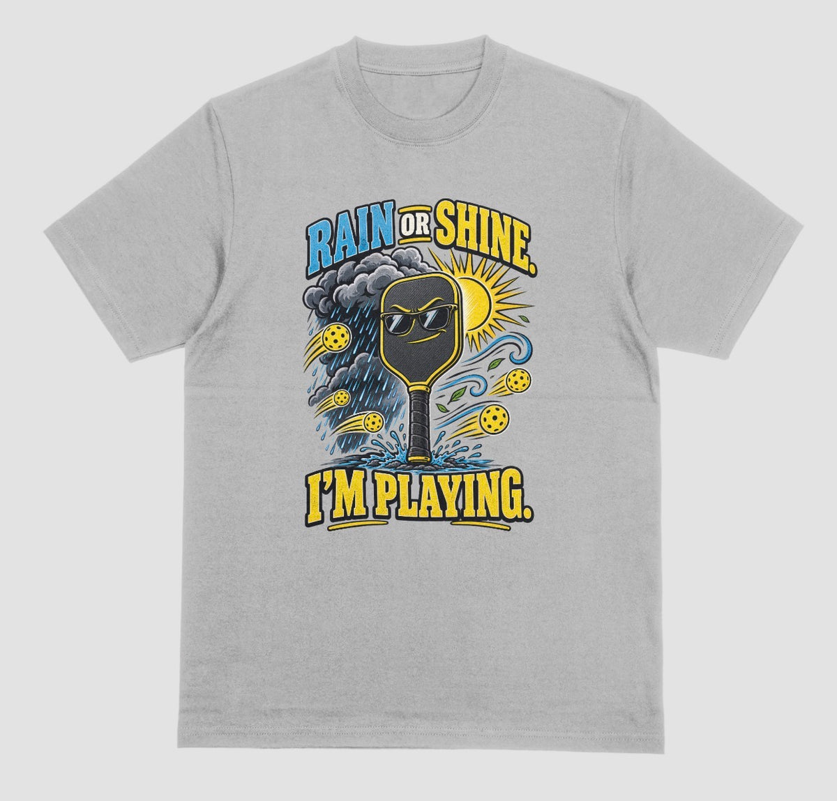 A grey Funny pickleball shirt with a sunglasses paddle, storm cloud and sun that says Rain or Shine, I’m Playing