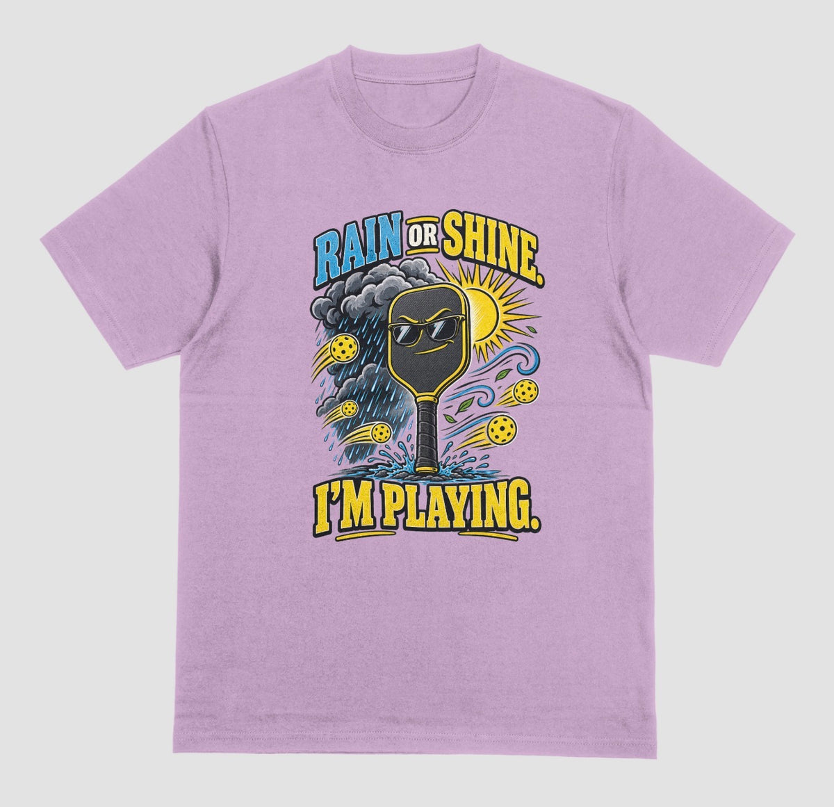 A light orchid Funny pickleball shirt with a sunglasses paddle, storm cloud and sun that says Rain or Shine, I’m Playing