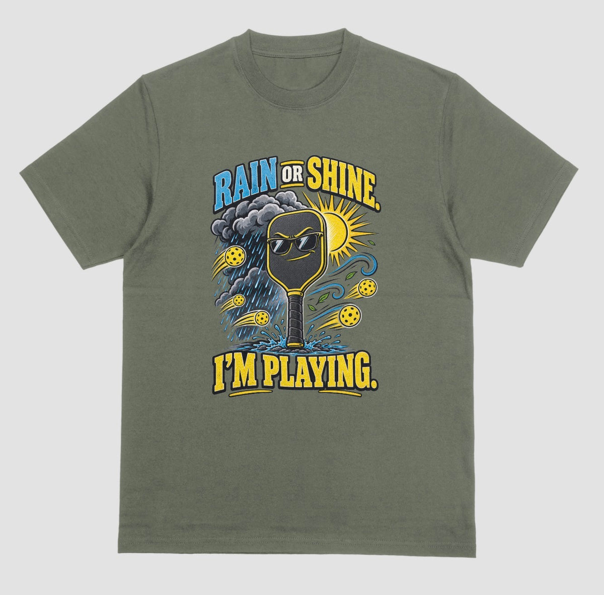 A military green Funny pickleball shirt with a sunglasses paddle, storm cloud and sun that says Rain or Shine, I’m Playing