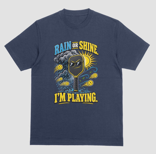 A navy blue Funny pickleball shirt with a sunglasses paddle, storm cloud and sun that says Rain or Shine, I’m Playing