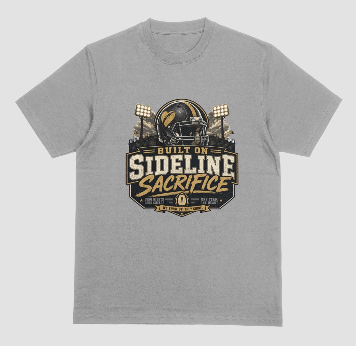 A grey crewneck t-shirt featuring a football-themed graphic on the chest with the text 'BUILT ON SIDELINE SACRIFICE' and a helmet illustration, shown against a light gray background.