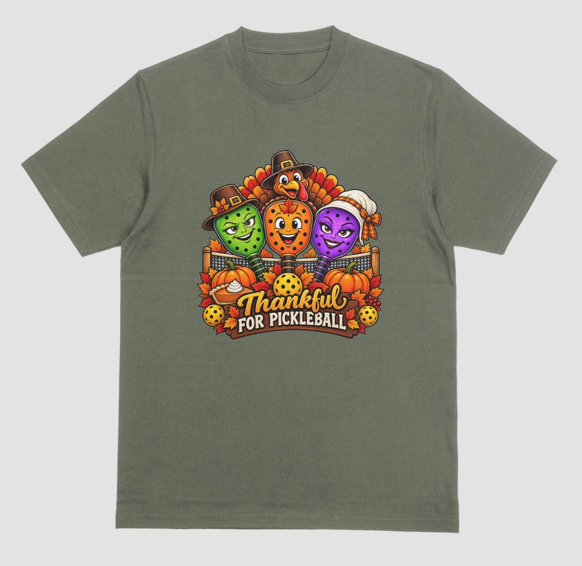 A military green t-shirt with “Thankful for Pickleball” design of three pilgrim-hat paddles, a turkey, pumpkins, and pie